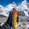 A Mountain climber holding Fit&Wise Portable Oxygen Can at high altitude place